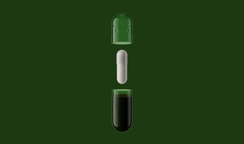 Three capsules with different contents on a green background