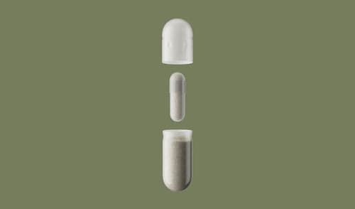 Two white capsules on a green background